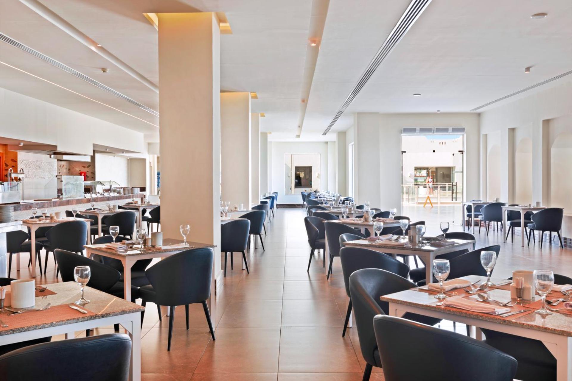 Pickalbatros Royal Grand Sharm - Adults Friendly 16 Years Plus Exteriör bild The photo shows the interior of a modern restaurant. The space is bright and airy, featuring large windows that allow natural light to flood in. There are several tables arranged throughout the room, each covered with placemats and set with glasses a