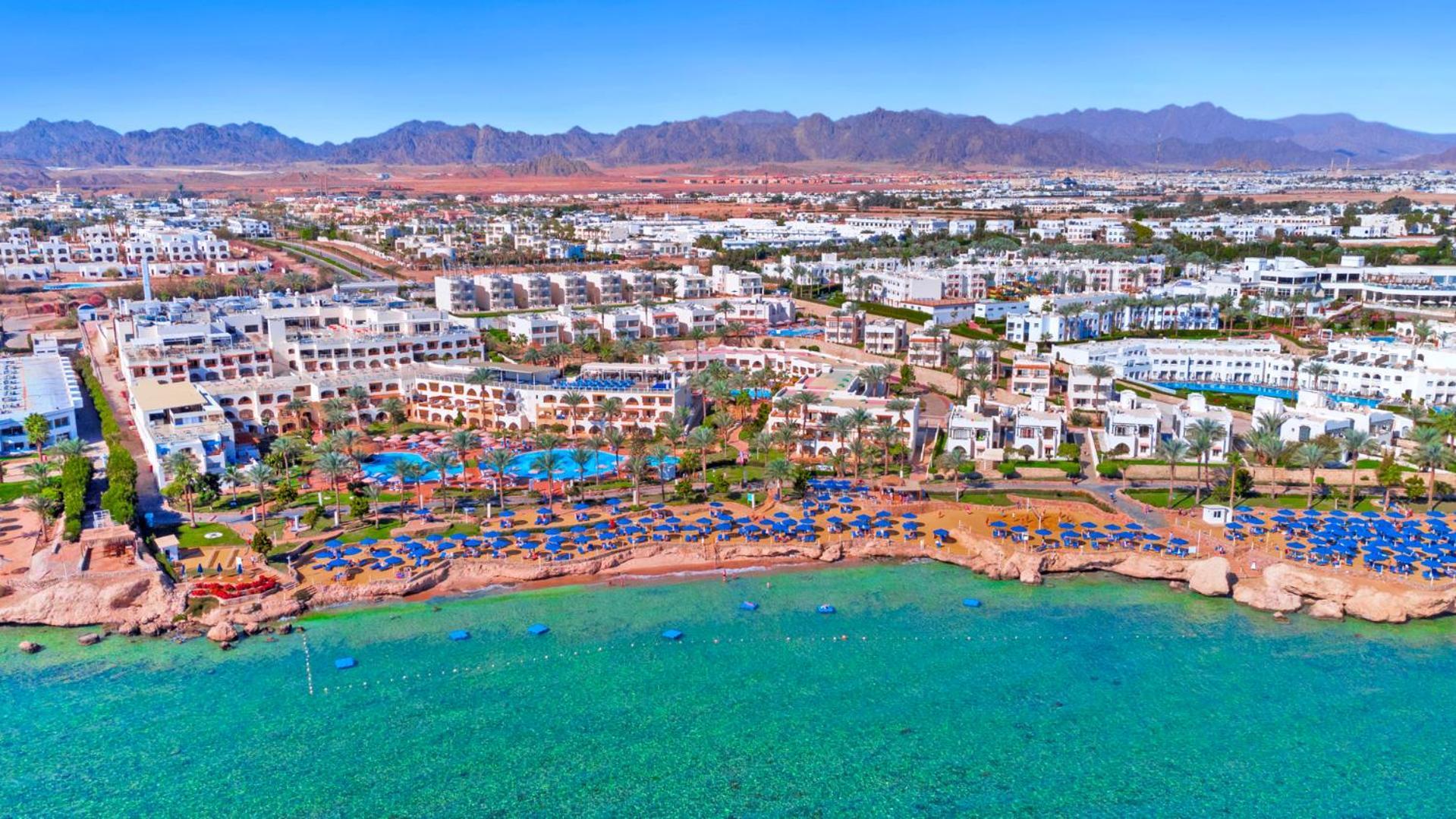 Pickalbatros Royal Grand Sharm - Adults Friendly 16 Years Plus Exteriör bild The photo shows an aerial view of a resort located by the coast. There are several swimming pools surrounded by sun loungers and umbrellas, as well as a beach area with clear turquoise water. In the background, there are multiple buildings of the res
